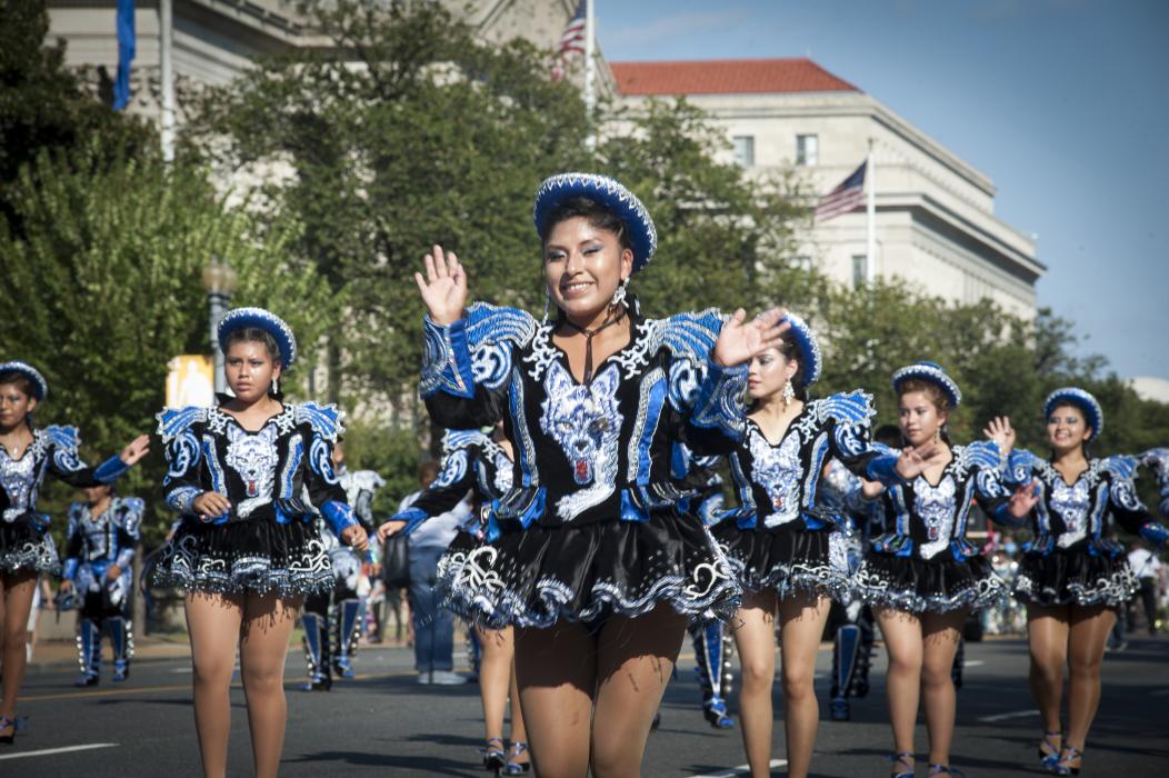 Group of women in a parade wearing a black and blue outfit 