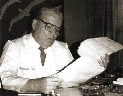 El Dr. C. David Molina leyendo un documento 