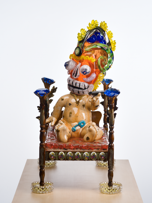 ¡2020¡ a sculpture by the de la Torre Brothers, baby with a blown glass skull head on a bed seen from the front. 