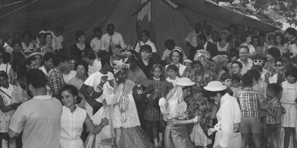 Celebración en un parque con multitud bailando.