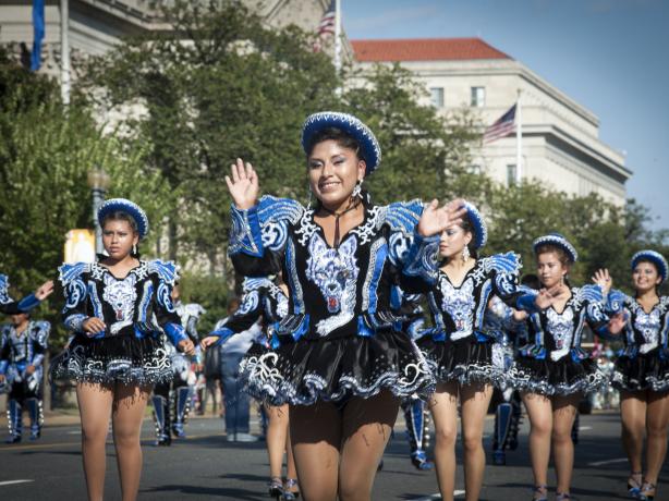Group of women in a parade wearing a black and blue outfit 