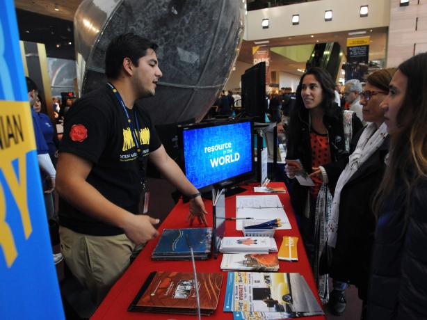 A young ambassador at a both speaking with visitors
