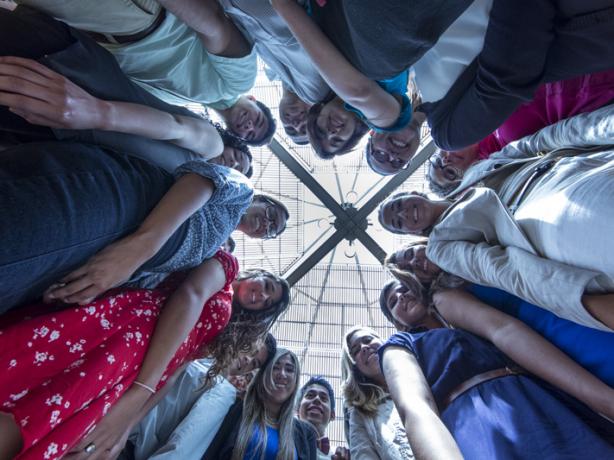 Group of people looking down at a camera