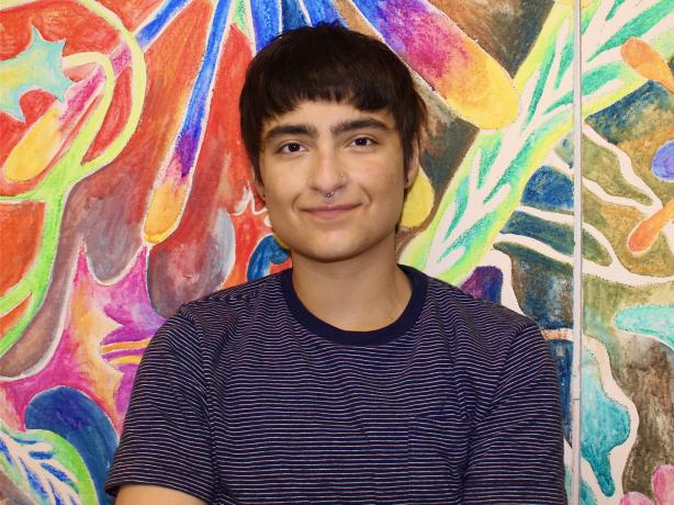 Headshot of a person wearing a striped navy and white t-shirt.
