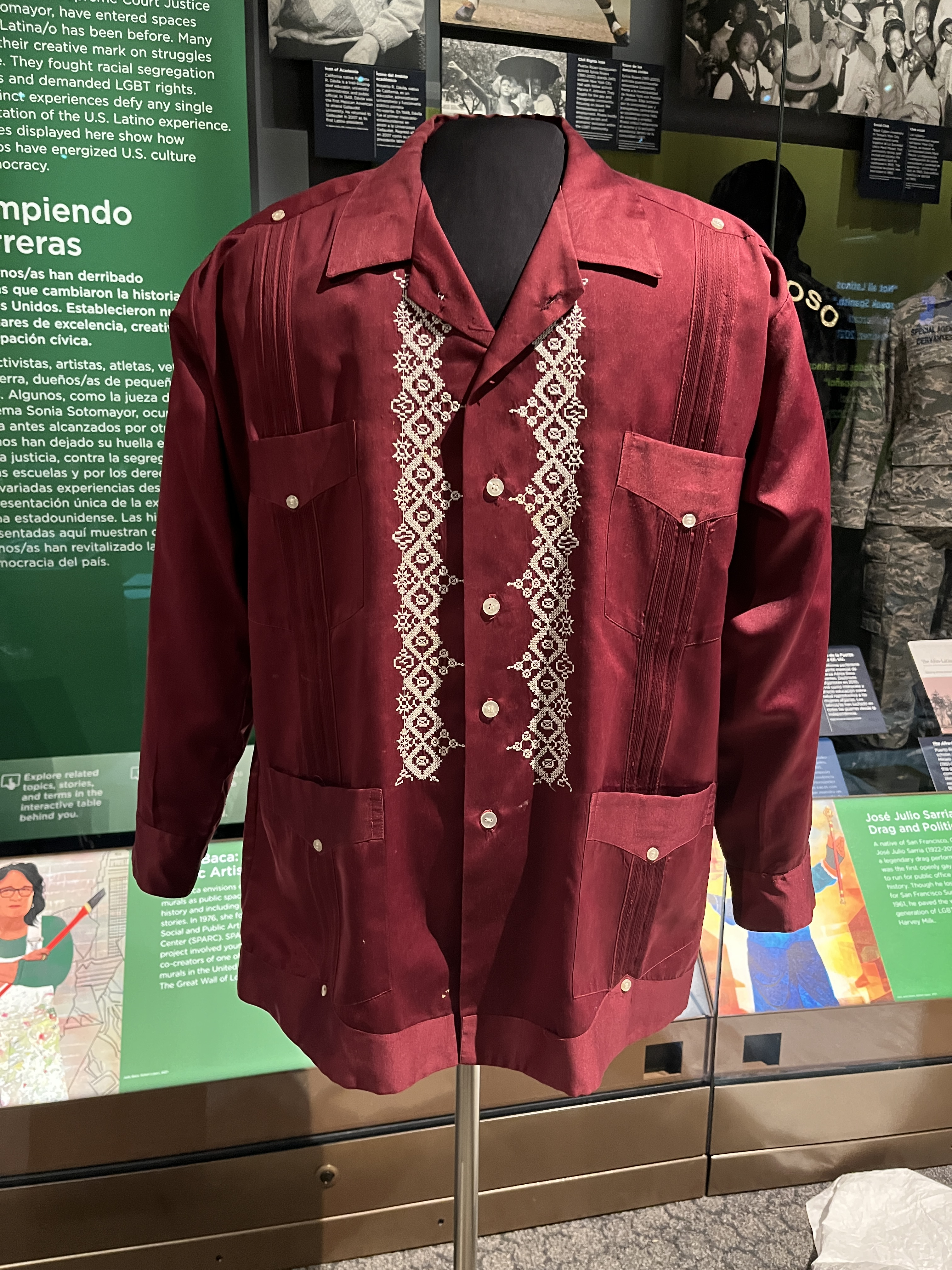 L2-0002208-D1-2023.05.22 Red guayabera shirt with white lace like embroidery down the front.