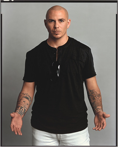 Pitbull Portrait of singer Pitbul standing and extending his hands down and wide open.